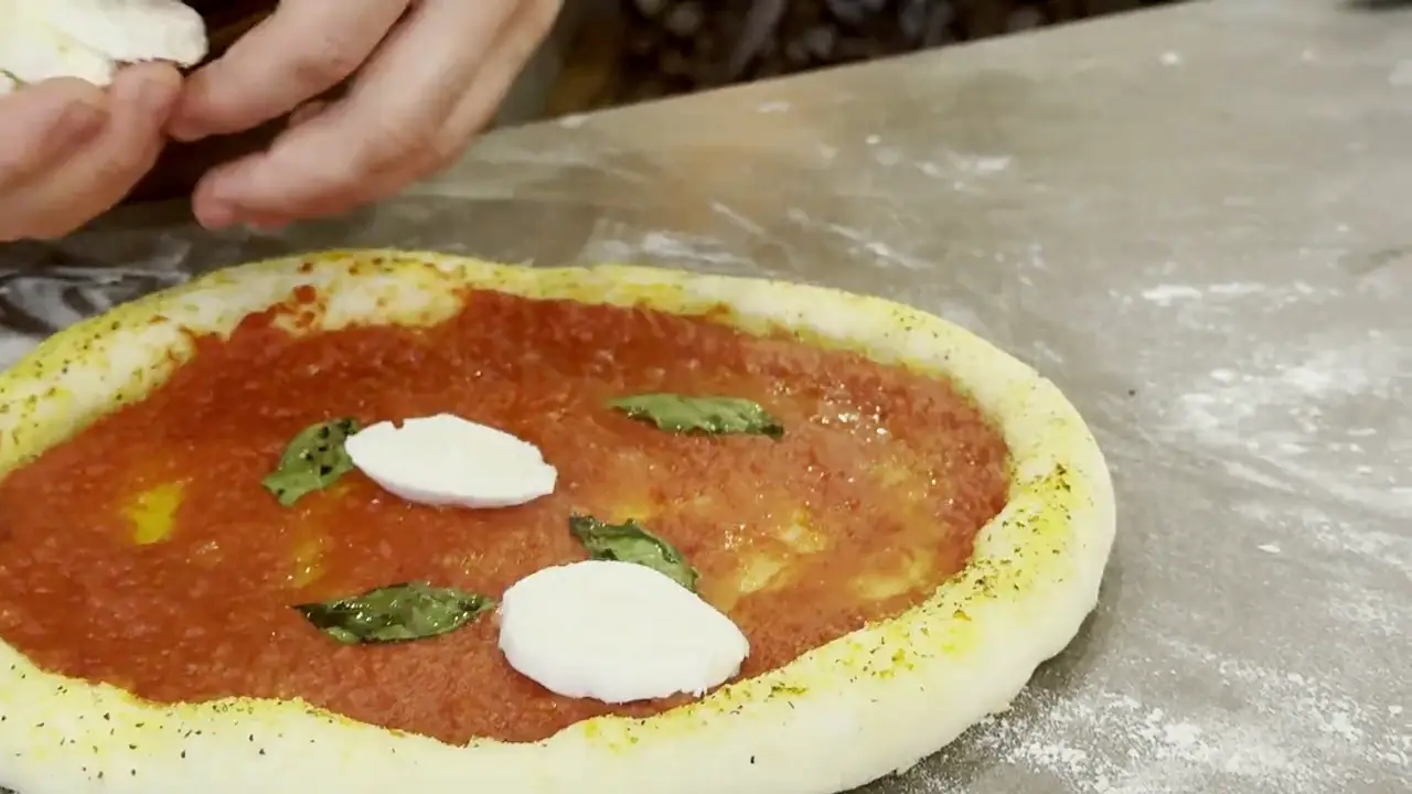 Le mani del pizzaiolo al lavoro